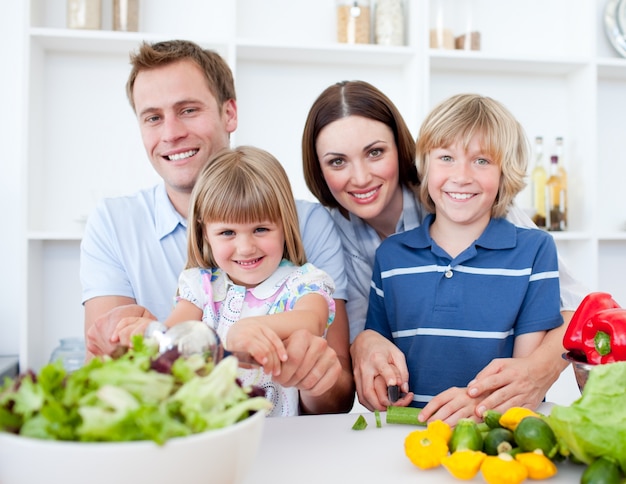 Giovane famiglia allegra che cucina insieme