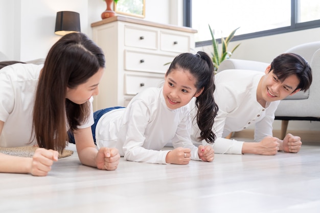 Giovane famiglia asiatica facendo esercizio insieme a casa