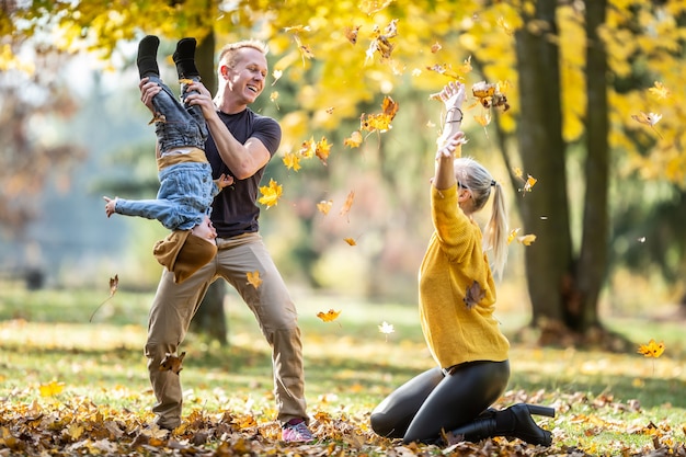 Giovane famiglia che fa scherzi all'aperto in una giornata autunnale.