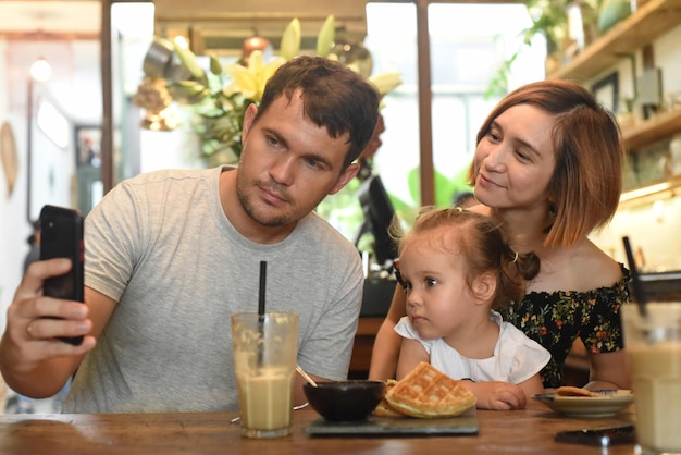 Giovane famiglia che fa selfie in una caffetteria