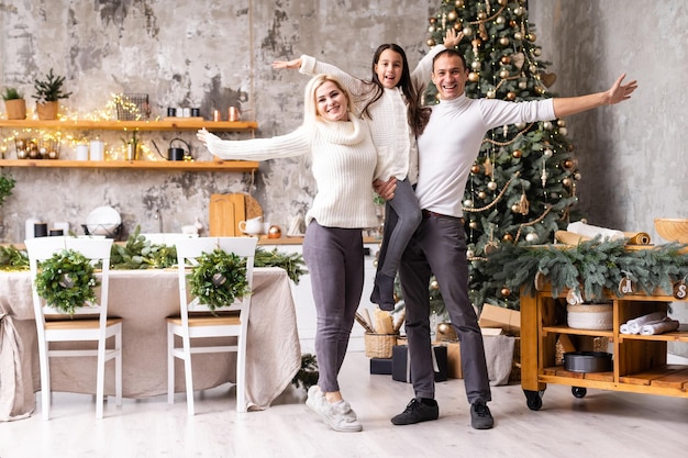 Giovane famiglia che festeggia il Natale a casa. Felice giovane famiglia godendo il loro tempo di vacanza insieme.