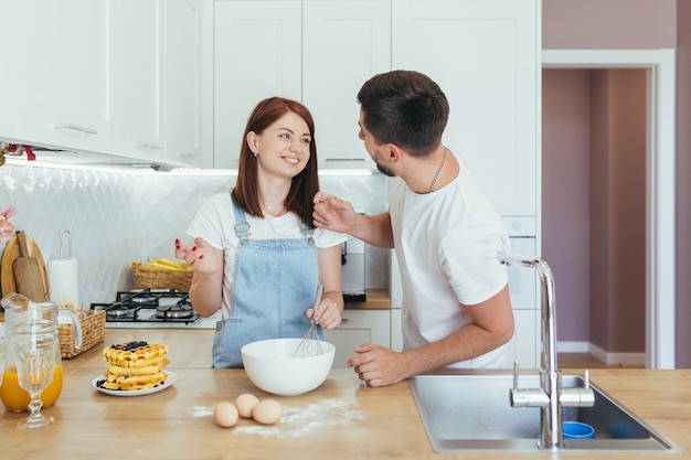 Giovane famiglia che prepara la colazione insieme, marito e donna felice