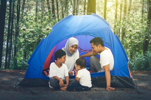 Giovane famiglia che si accampa insieme nella foresta