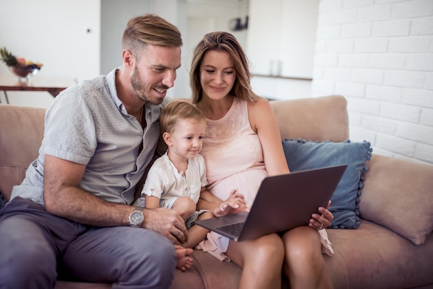 Giovane famiglia che si diverte insieme al computer portatile