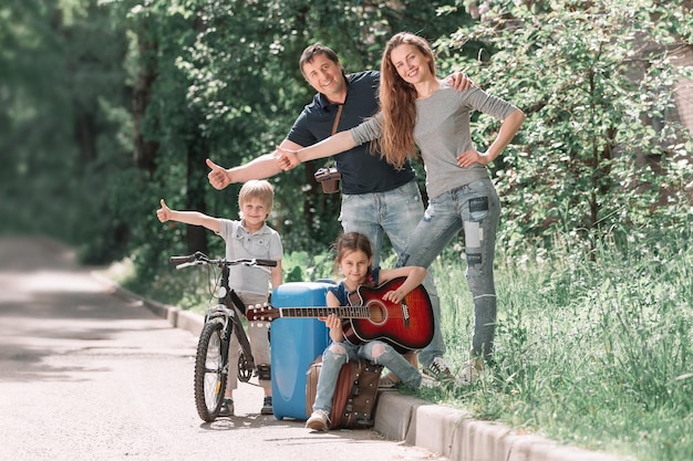 Giovane famiglia con bambini che viaggiano in autostop