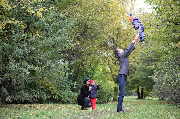 Giovane famiglia con bambini in una passeggiata nel parco in primavera