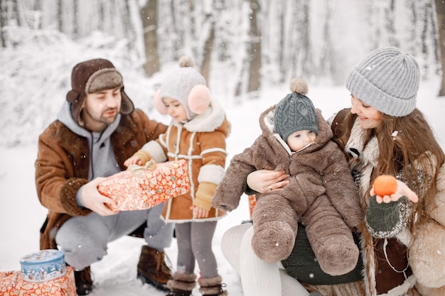 Giovane famiglia con due bambini nella foresta invernale e in posa per una foto