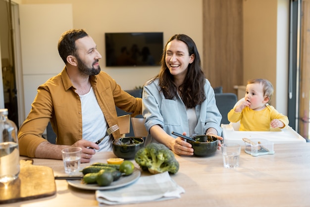 Giovane famiglia con un bambino di un anno durante l'ora di pranzo a casa