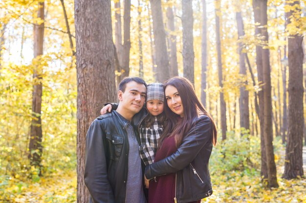 Giovane famiglia di razza mista che cammina nel parco in giorno di autunno