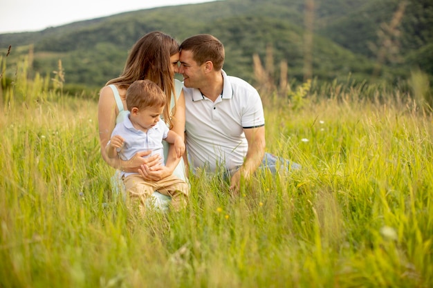 Giovane famiglia divertendosi all'aperto nel campo estivo