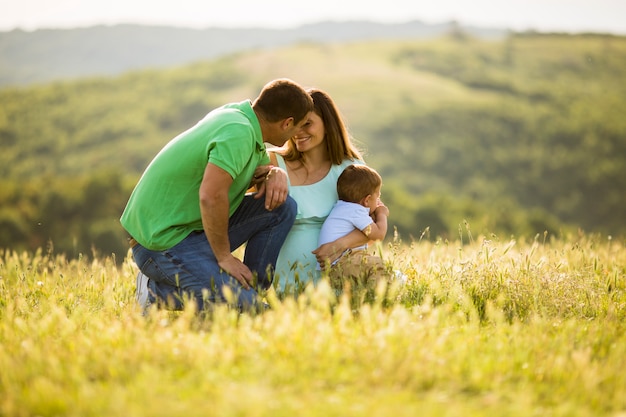 Giovane famiglia divertendosi all'aperto nel campo