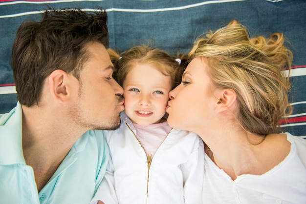 Giovane famiglia felice che bacia bambina.