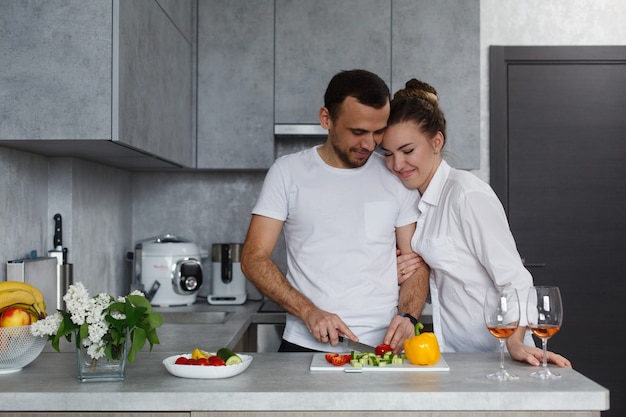 Giovane famiglia felice che cucina insieme