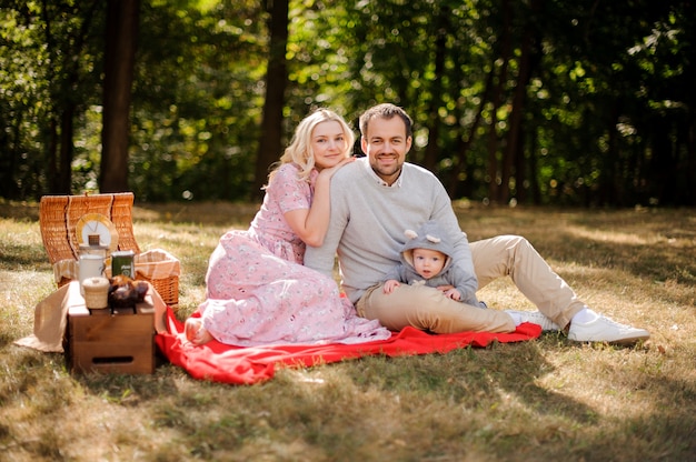 Giovane famiglia felice con il bambino sul picnic