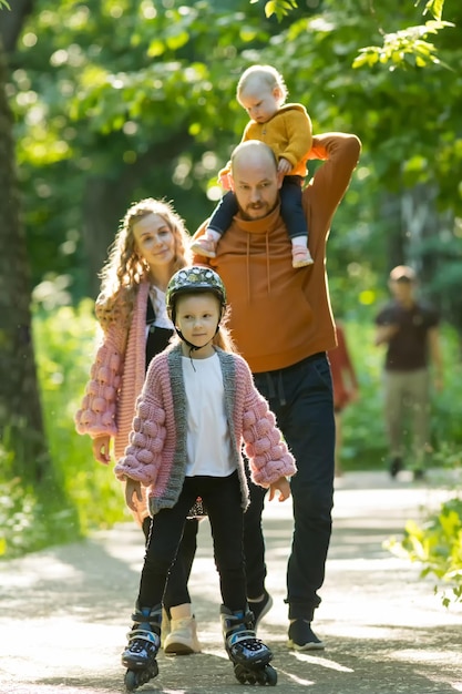Giovane famiglia felice di genitori e due bambini piccoli che camminano nella foresta estiva