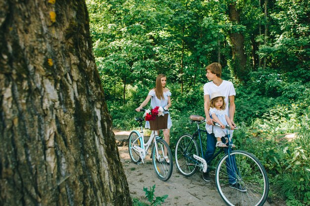 Giovane famiglia felice di trascorrere del tempo insieme fuori. Generi la madre ed il loro bambino nel parco verde su un picnic