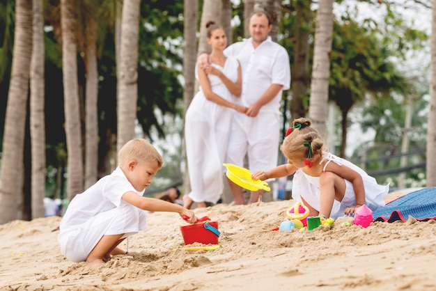 Giovane famiglia felice sul tramonto sulla spiaggia.