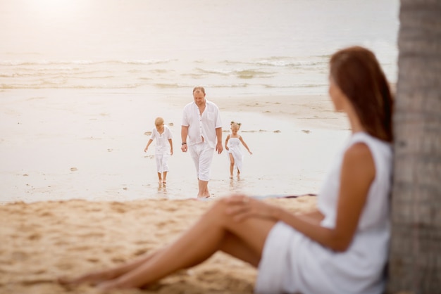 Giovane famiglia felice sul tramonto sulla spiaggia.