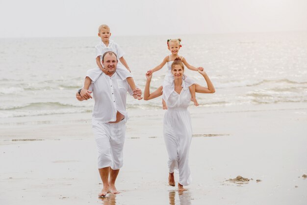 Giovane famiglia felice sul tramonto sulla spiaggia.