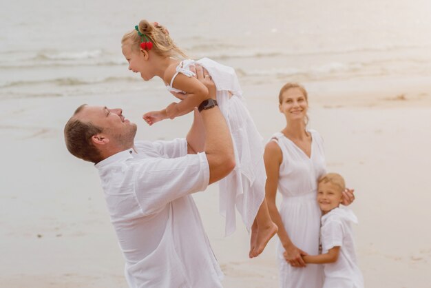 Giovane famiglia felice sul tramonto sulla spiaggia.