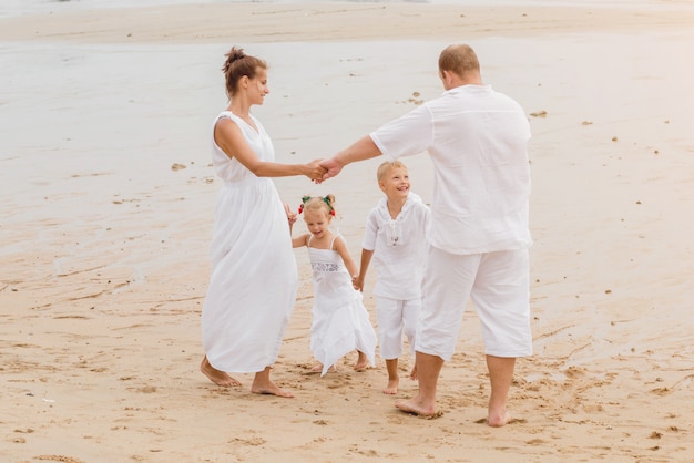 Giovane famiglia felice sul tramonto sulla spiaggia.