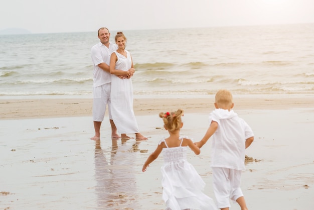 Giovane famiglia felice sul tramonto sulla spiaggia.