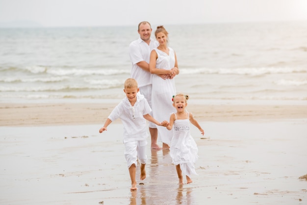 Giovane famiglia felice sul tramonto sulla spiaggia.