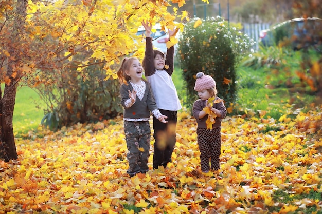 Giovane famiglia in una passeggiata nel parco autunnale in una giornata di sole. Felicità di stare insieme.