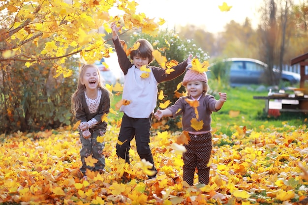 Giovane famiglia in una passeggiata nel parco autunnale in una giornata di sole. Felicità di stare insieme.