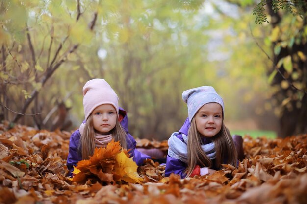 Giovane famiglia in una passeggiata nel parco autunnale in una giornata di sole. Felicità di stare insieme.