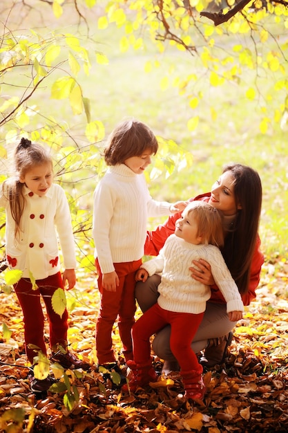 Giovane famiglia in una passeggiata nel parco autunnale in una giornata di sole. Felicità di stare insieme.