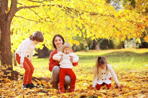 Giovane famiglia in una passeggiata nel parco autunnale in una giornata di sole. Felicità di stare insieme.