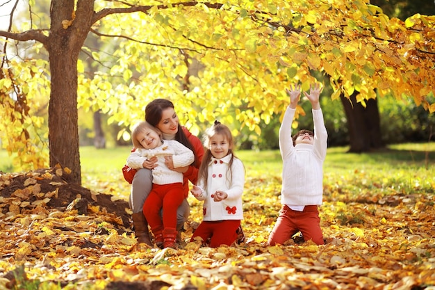 Giovane famiglia in una passeggiata nel parco autunnale in una giornata di sole. Felicità di stare insieme.