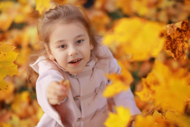 Giovane famiglia in una passeggiata nel parco autunnale in una giornata di sole. Felicità di stare insieme.