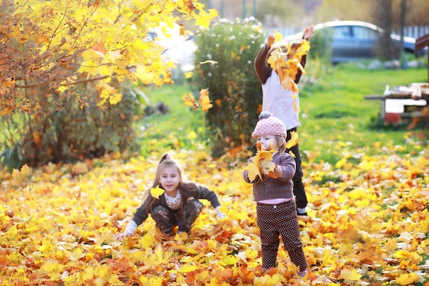 Giovane famiglia in una passeggiata nel parco autunnale in una giornata di sole. Felicità di stare insieme.