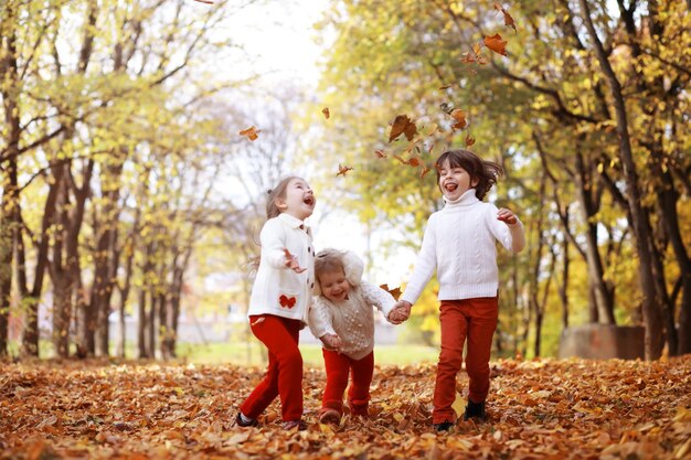 Giovane famiglia in una passeggiata nel parco autunnale in una giornata di sole. Felicità di stare insieme.