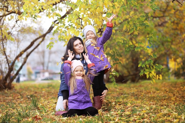 Giovane famiglia in una passeggiata nel parco autunnale in una giornata di sole. Felicità di stare insieme.