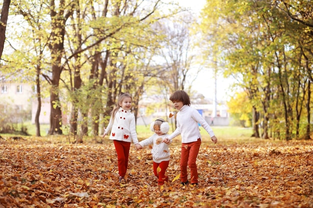 Giovane famiglia in una passeggiata nel parco autunnale in una giornata di sole Felicità di stare insieme