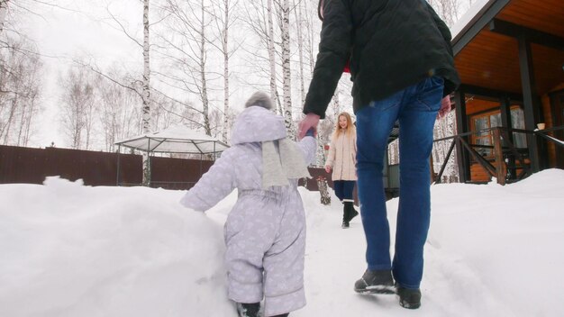 Giovane famiglia invernale che cammina con il loro bambino nel cortile