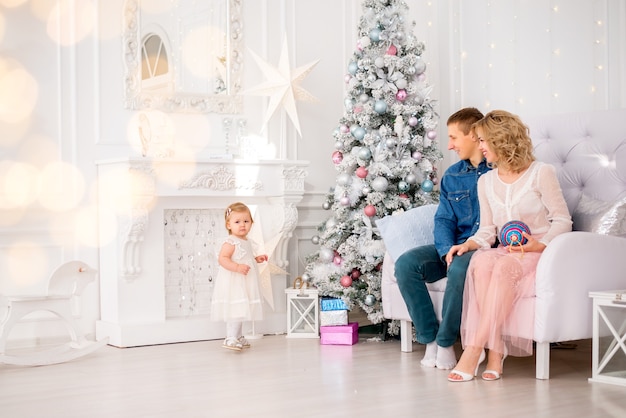 Giovane famiglia. Mamma, papà e figlia piccola decorano l'albero di Natale. preparazione per il Natale.