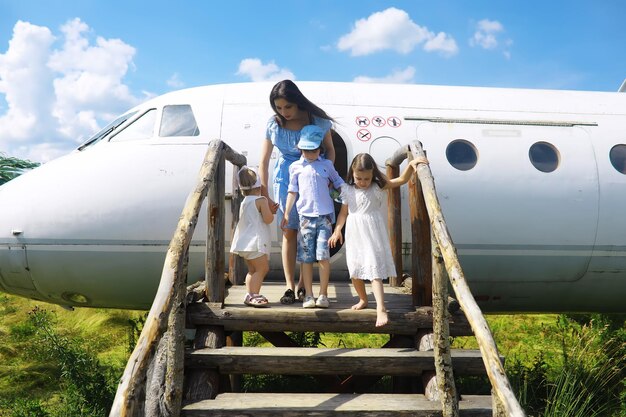 Giovane famiglia numerosa in una passeggiata mattutina estiva Bella madre con bambini sta giocando nel parco