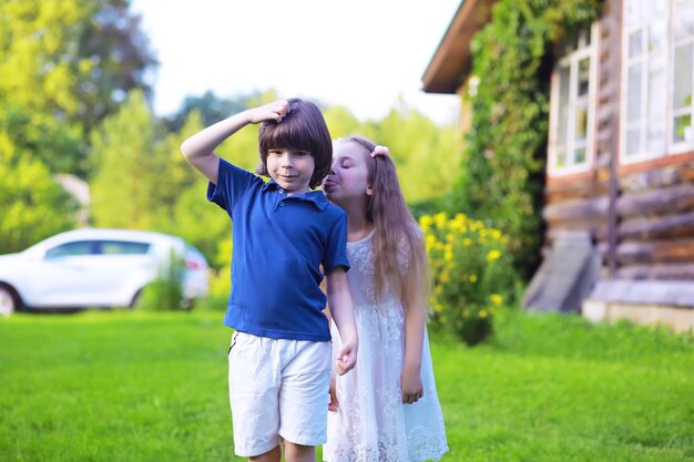 Giovane famiglia numerosa in una passeggiata mattutina estiva. La bella madre con i bambini sta giocando nel parco.