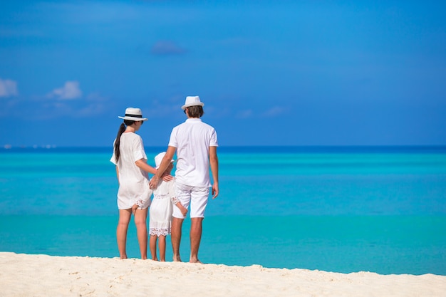 Giovane famiglia sulla spiaggia bianca durante le vacanze estive