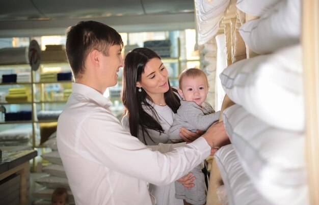 Giovane famiglia sullo shopping Coppia sposata e un bambino che cammina nel negozio Metà del colpo