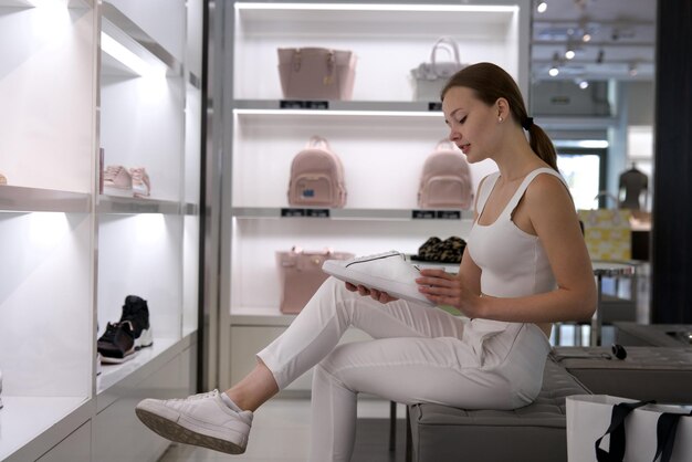 Giovane felice bella donna ragazza elegante sta facendo acquisti nel centro commerciale all'aperto tenendo borse in mano