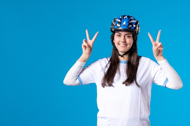 Giovane femmina felice di vista frontale in vestiti di sport con il casco