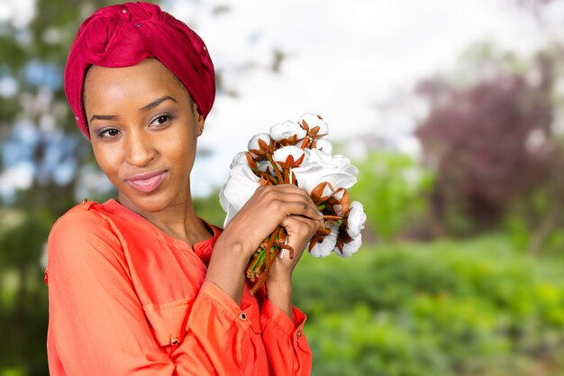 Giovane fiore africano allegro della tenuta della donna