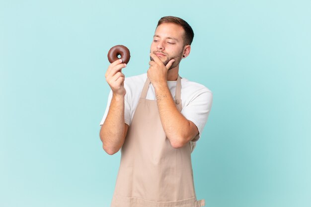 Giovane fornaio bello con una ciambella