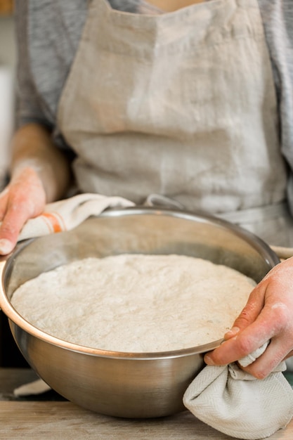 Giovane fornaio che prepara pane a lievitazione naturale artigianale.