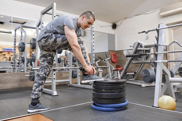 Giovane forte uomo muscoloso in palestra